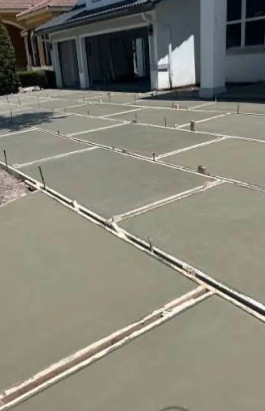Turf-strip concrete driveway pads being formed and poured at a Los Angeles home